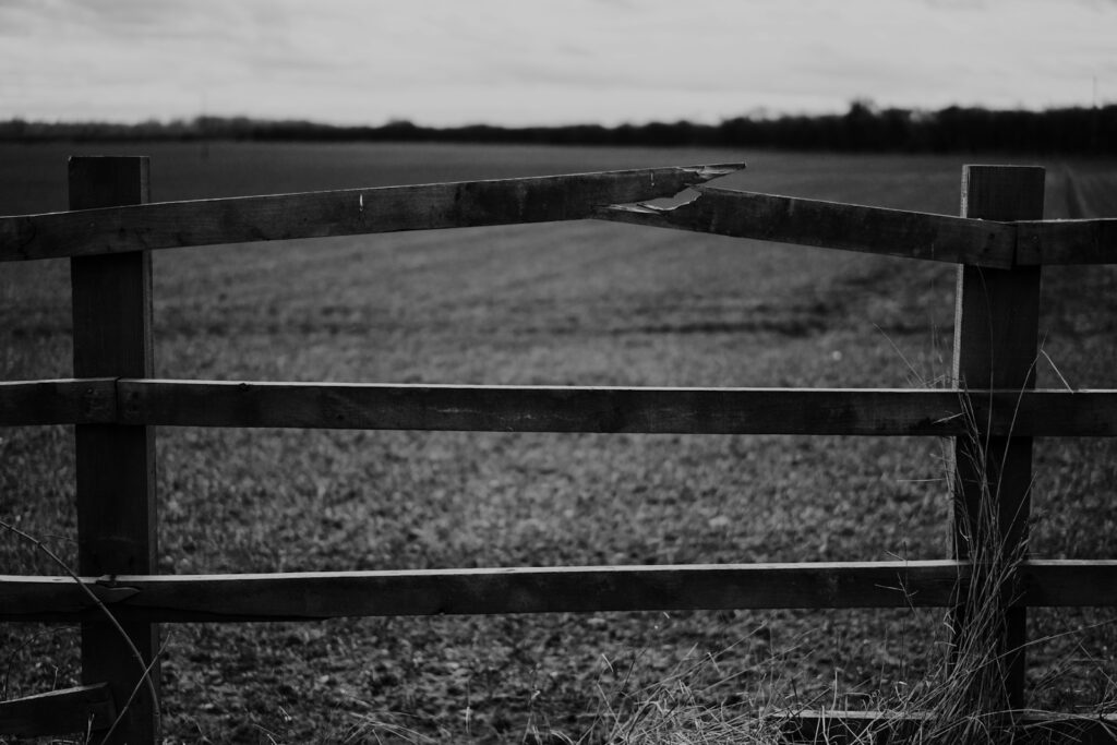 a black and white photo of a wooden fence