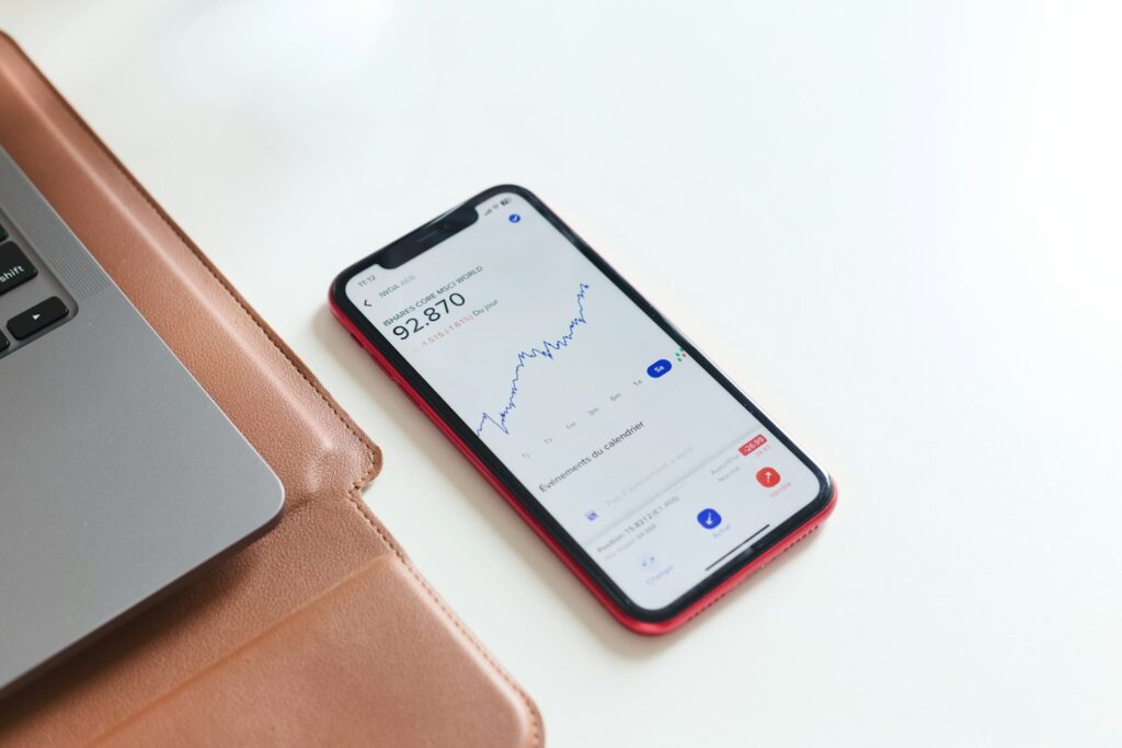 A cell phone sitting next to a laptop on a desk